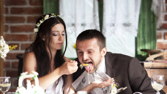 Bride and groom are eating at the wedding reception
